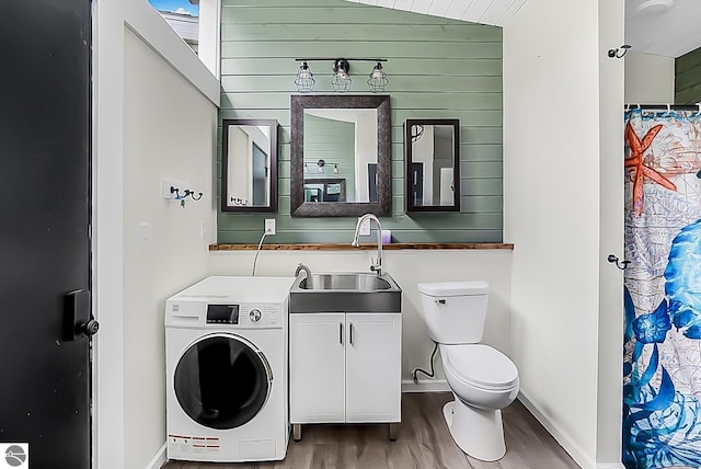 100 Fence Row Cir, Leroy, MI 49655 - full bath with washer / clothes dryer, wood finished floors, toilet, baseboards, and vanity