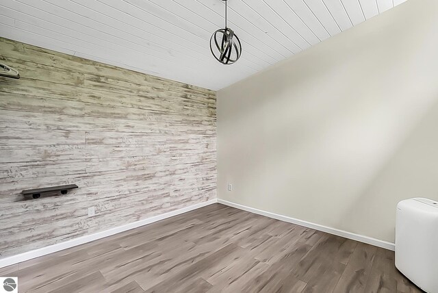 100 Fence Row Cir, Leroy, MI 49655 - unfurnished dining area with baseboards, dark wood-type flooring, wooden walls, and wood ceiling