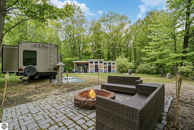 100 Fence Row Cir, Leroy, MI 49655 - view of patio / terrace featuring a fire pit, an outdoor structure, and view of wooded area