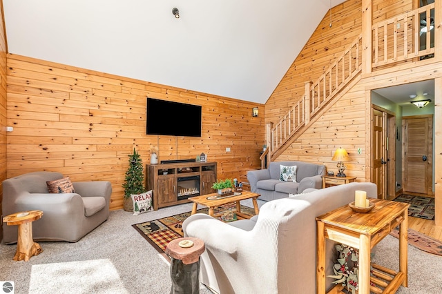 1715 Sunrise Dr, Greenbush, MI 48738 - living room featuring high vaulted ceiling, wooden walls, and carpet floors