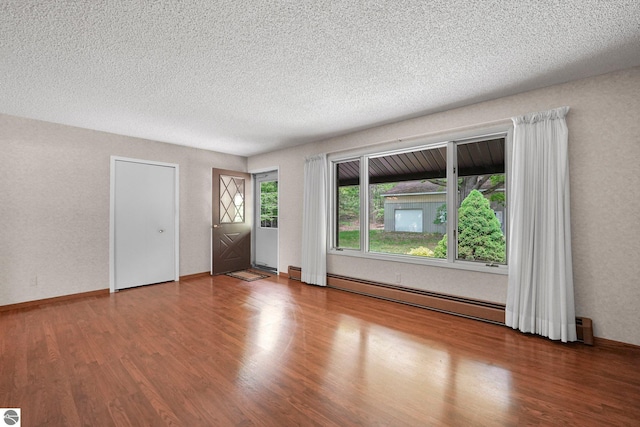 9017 Clam Lake Rd, Bellaire, MI 49615 - unfurnished living room with a baseboard radiator, wood finished floors, and a textured ceiling