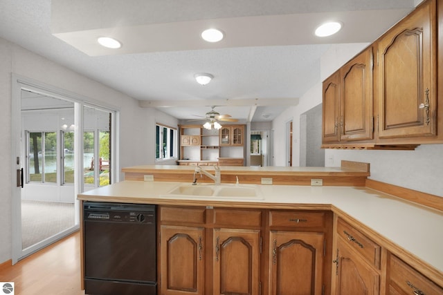 9017 Clam Lake Rd, Bellaire, MI 49615 - kitchen featuring dishwasher, a sink, a peninsula, brown cabinets, and light countertops