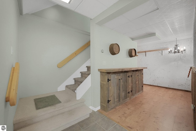 9017 Clam Lake Rd, Bellaire, MI 49615 - stairs featuring a chandelier and baseboards