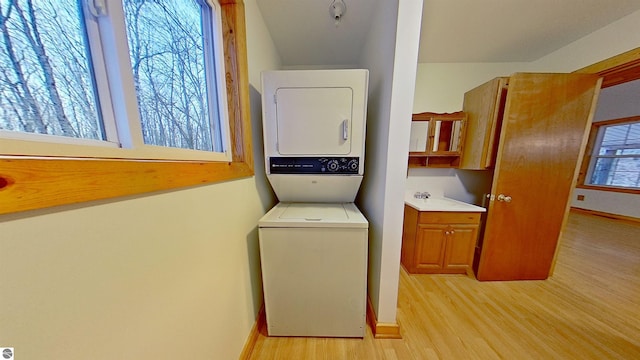 350 Mcmorris Trl, Harrison, MI 48625 - laundry room featuring estacked washer and dryer, light wood-type flooring, and baseboards