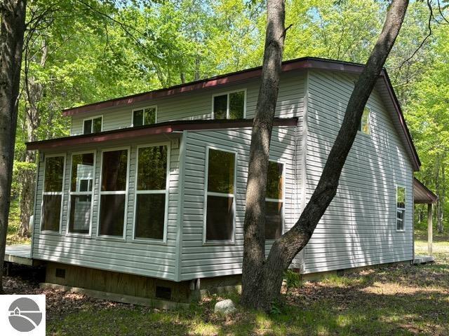 350 Mcmorris Trl, Harrison, MI 48625 - view of property exterior featuring crawl space and view of wooded area