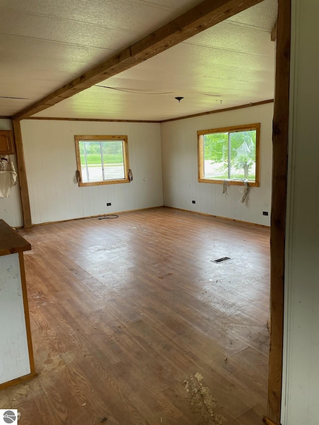 8055 S Castle Dr, Sheridan, MI 48884 - empty room with beam ceiling, wood finished floors, and wooden walls