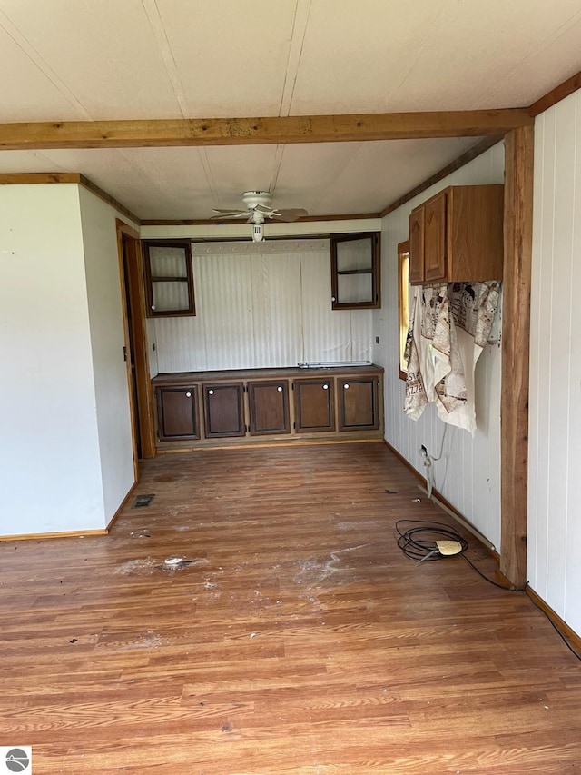 8055 S Castle Dr, Sheridan, MI 48884 - empty room featuring light wood-style floors, beamed ceiling, a ceiling fan, and wood walls