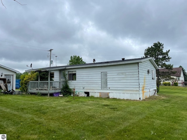 8055 S Castle Dr, Sheridan, MI 48884 - back of property featuring a yard and a wooden deck