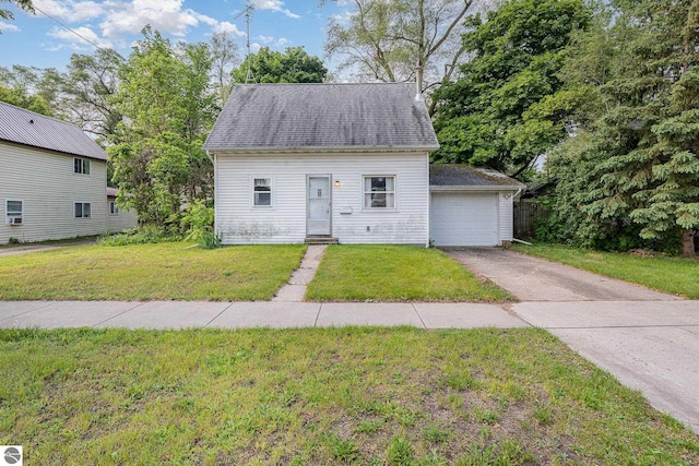 212 Palmer St, Mount Pleasant, MI 48858 - new england style home featuring asphalt driveway, a front lawn, and a garage