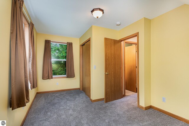 212 Palmer St, Mount Pleasant, MI 48858 - unfurnished bedroom with carpet, baseboards, and a closet