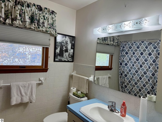 217 Evans St, East Tawas, MI 48730 - bathroom featuring tile walls, vanity, toilet, and curtained shower