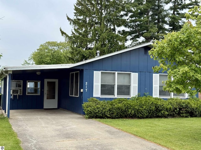 217 Evans St, East Tawas, MI 48730 - view of front of home with an attached carport, driveway, a front lawn, and board and batten siding