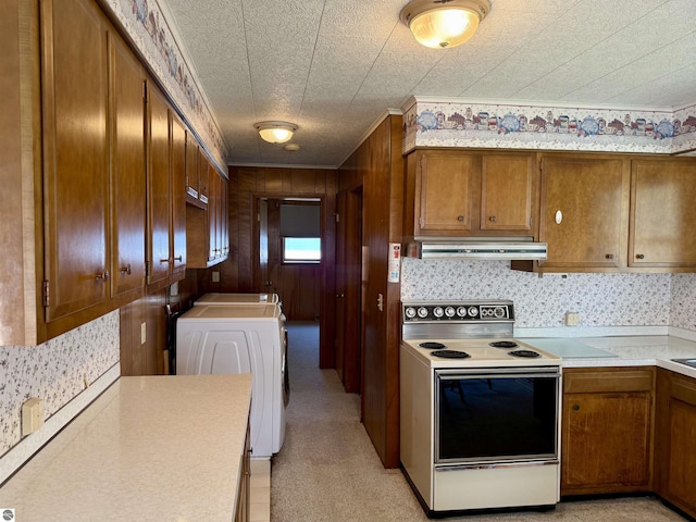 217 Evans St, East Tawas, MI 48730 - kitchen featuring white range with electric stovetop, brown cabinetry, washer / clothes dryer, light countertops, and wood walls