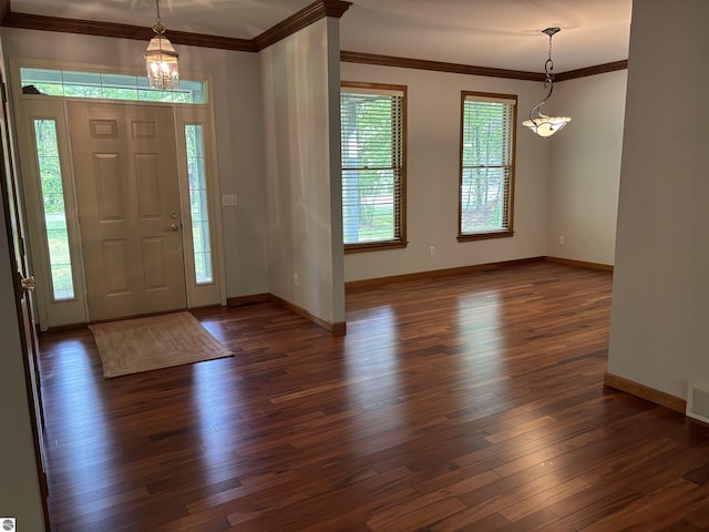 5867 Huron Woods Dr, Tawas City, MI 48763 - foyer entrance featuring a chandelier, healthy amount of natural light, dark wood-style floors, and ornamental molding