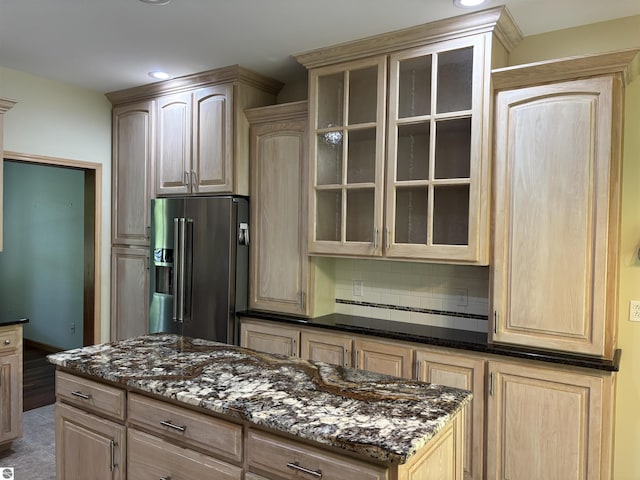 5867 Huron Woods Dr, Tawas City, MI 48763 - kitchen with high quality fridge, dark stone counters, glass insert cabinets, tasteful backsplash, and recessed lighting