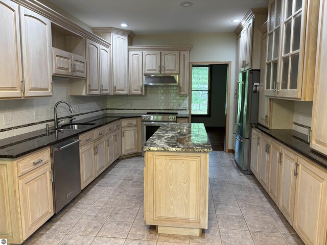 5867 Huron Woods Dr, Tawas City, MI 48763 - kitchen with stainless steel appliances, under cabinet range hood, a kitchen island, backsplash, and a sink