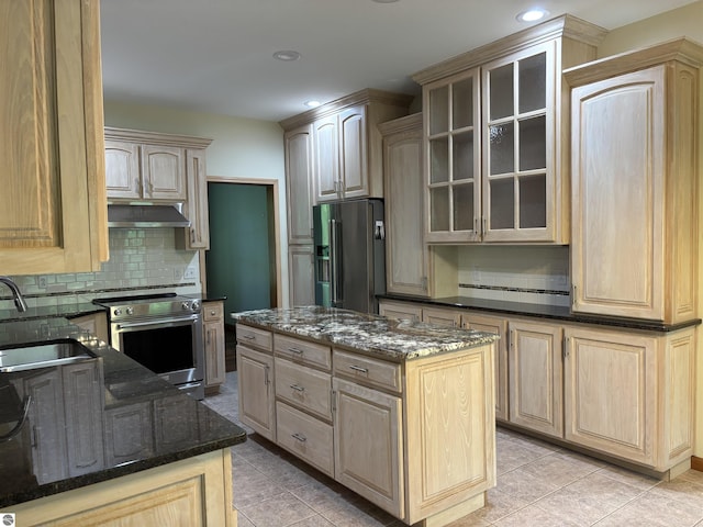 5867 Huron Woods Dr, Tawas City, MI 48763 - kitchen featuring appliances with stainless steel finishes, a sink, decorative backsplash, light tile patterned flooring, and glass insert cabinets