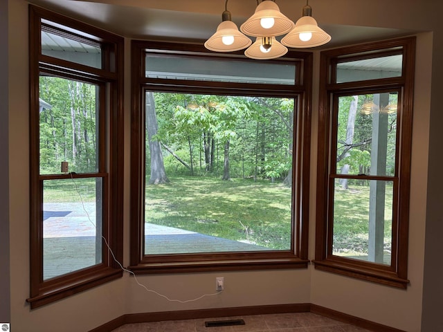 5867 Huron Woods Dr, Tawas City, MI 48763 - unfurnished dining area with tile patterned flooring and baseboards