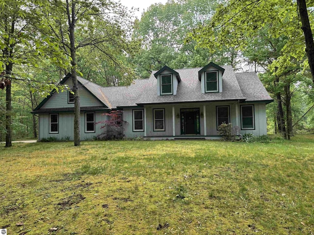 5867 Huron Woods Dr, Tawas City, MI 48763 - view of front of home with covered porch, a front yard, and roof with shingles