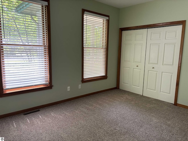 5867 Huron Woods Dr, Tawas City, MI 48763 - unfurnished bedroom featuring carpet flooring, a closet, and baseboards