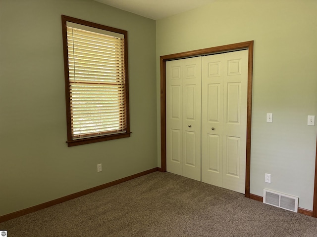 5867 Huron Woods Dr, Tawas City, MI 48763 - unfurnished bedroom featuring carpet floors, a closet, and baseboards