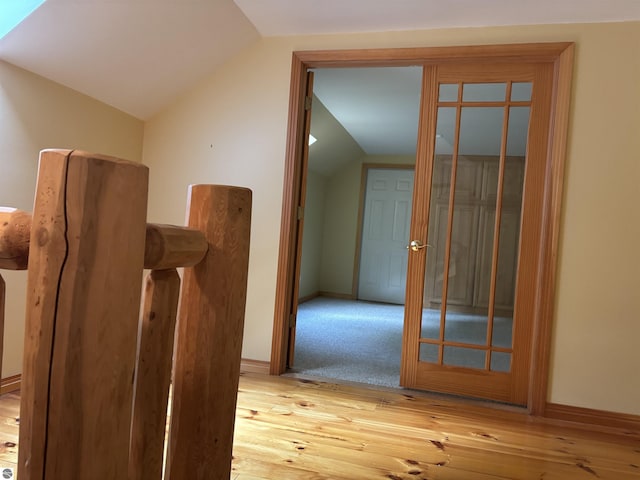 5867 Huron Woods Dr, Tawas City, MI 48763 - hallway with lofted ceiling, light wood-style floors, and baseboards