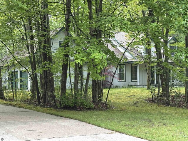 5867 Huron Woods Dr, Tawas City, MI 48763 - view of side of property featuring board and batten siding and a yard