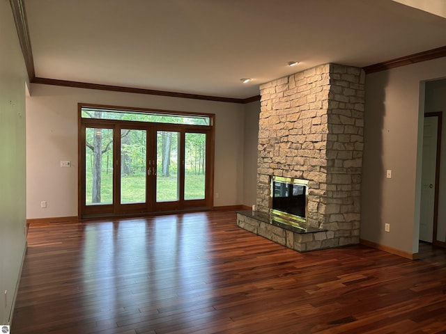 5867 Huron Woods Dr, Tawas City, MI 48763 - unfurnished living room featuring ornamental molding, baseboards, wood finished floors, and a stone fireplace