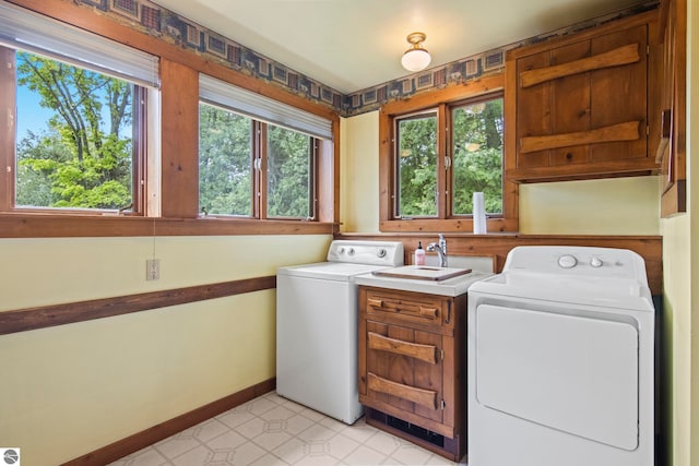 12570 N Cathead Point Rd, Northport, MI 49670 - laundry room with cabinet space, plenty of natural light, washing machine and dryer, and baseboards