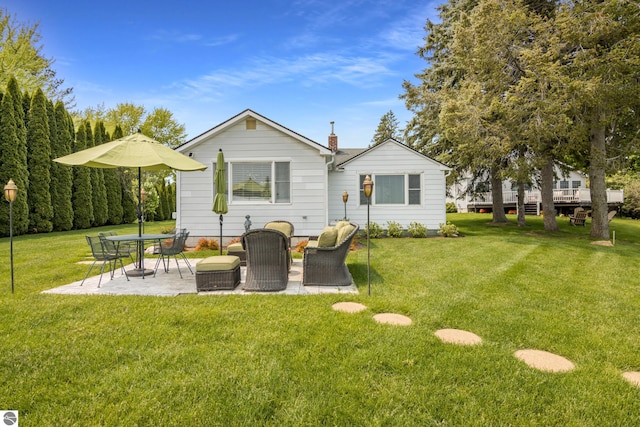 5896 S Cummings St, Suttons Bay, MI 49682 - back of house with a patio, a lawn, and a chimney