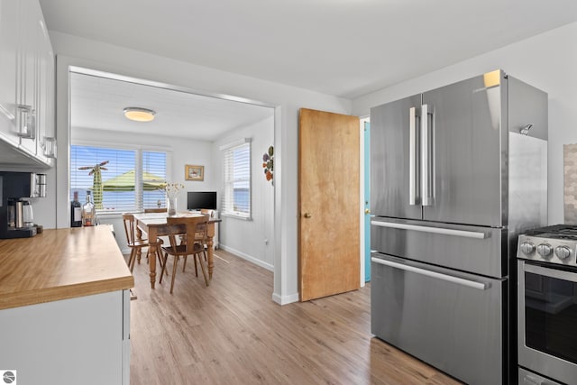 5896 S Cummings St, Suttons Bay, MI 49682 - kitchen featuring stainless steel appliances, light wood-style flooring, baseboards, white cabinets, and light countertops