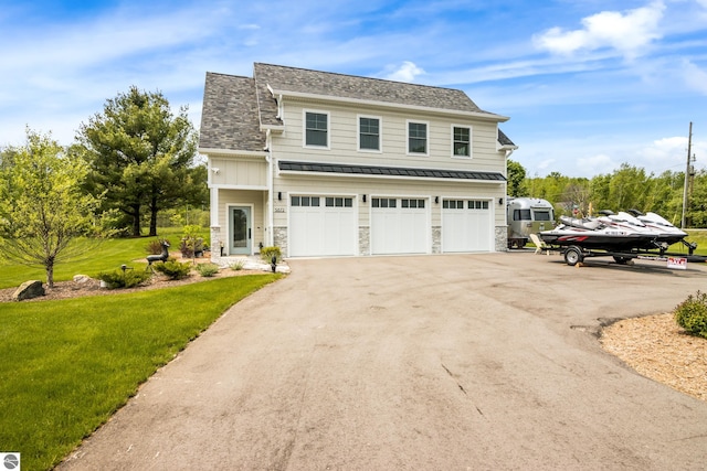 5896 S Cummings St, Suttons Bay, MI 49682 - traditional-style house with a standing seam roof, a front lawn, asphalt driveway, metal roof, and an attached garage