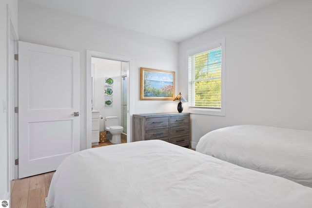 5896 S Cummings St, Suttons Bay, MI 49682 - bedroom featuring light wood-type flooring and connected bathroom