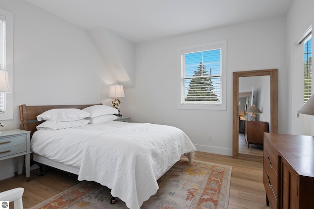 5896 S Cummings St, Suttons Bay, MI 49682 - bedroom featuring light wood finished floors and baseboards