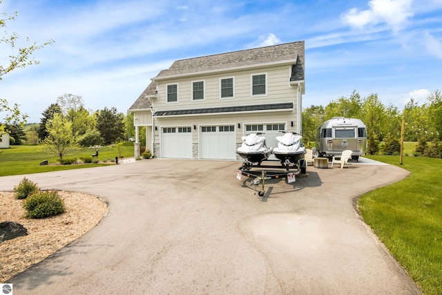 5896 S Cummings St, Suttons Bay, MI 49682 - view of front of property with a standing seam roof, asphalt driveway, a front yard, metal roof, and a garage