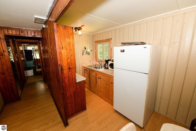 1650 N Huron, Tawas City, MI 48763 - kitchen featuring freestanding refrigerator, a sink, light wood-style flooring, light countertops, and brown cabinets