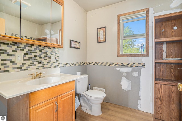4074 Filter Rd, Harrison, MI 48625 - bathroom featuring toilet, wood finished floors, vanity, and decorative backsplash