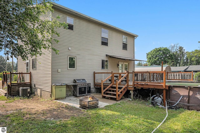 4074 Filter Rd, Harrison, MI 48625 - back of house with a fire pit, a wooden deck, a lawn, central AC unit, and a patio area