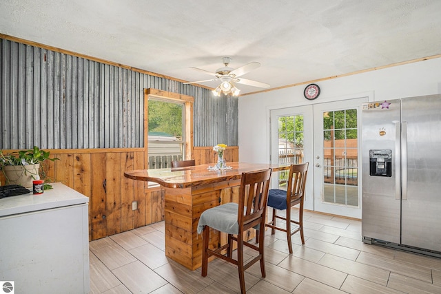 4074 Filter Rd, Harrison, MI 48625 - dining space featuring plenty of natural light, french doors, a ceiling fan, wood walls, and wainscoting