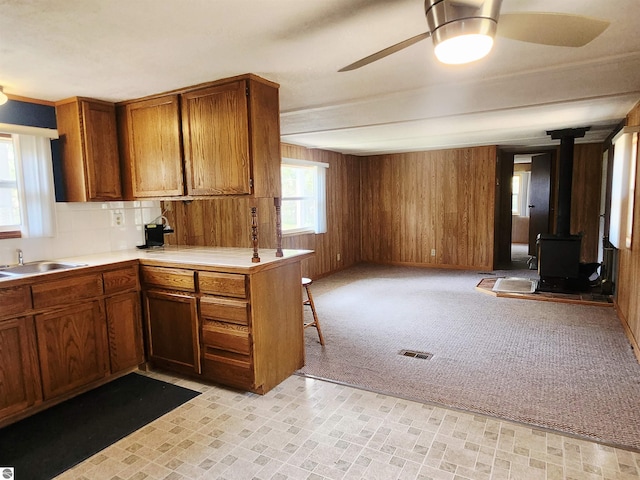 3764 E N Down River Rd, Grayling, MI 49738 - kitchen with a ceiling fan, a sink, brown cabinets, open floor plan, and wooden walls