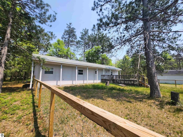 3764 E N Down River Rd, Grayling, MI 49738 - rear view of house with a deck, a yard, and metal roof