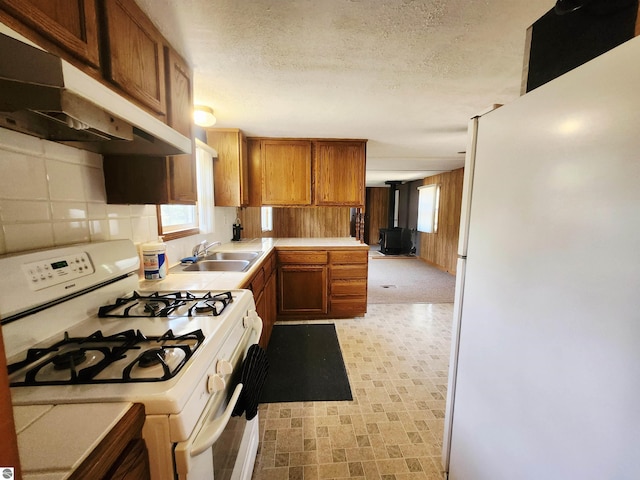 3764 E N Down River Rd, Grayling, MI 49738 - kitchen featuring white appliances, a sink, under cabinet range hood, light floors, and healthy amount of natural light