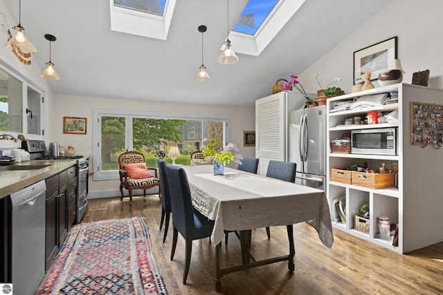 3362 S French Rd, Cedar, MI 49621 - dining room featuring a skylight, wood finished floors, and lofted ceiling