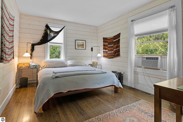 3362 S French Rd, Cedar, MI 49621 - bedroom featuring wooden walls, hardwood / wood-style floors, cooling unit, and multiple windows