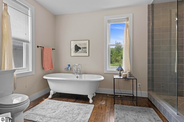 3362 S French Rd, Cedar, MI 49621 - full bathroom with a freestanding bath, hardwood / wood-style floors, baseboards, and toilet