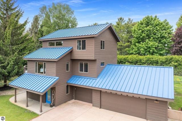 110 W Terrace Lane Commons, Leland, MI 49654 - rear view of property with a standing seam roof, metal roof, driveway, and a patio area