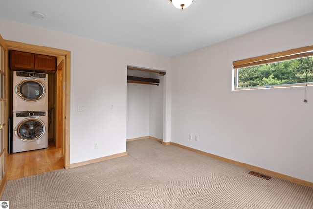 110 W Terrace Lane Commons, Leland, MI 49654 - unfurnished bedroom featuring estacked washer and dryer, baseboards, a closet, and light carpet
