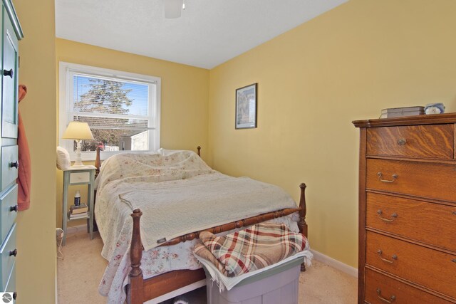 112 N Benzie Blvd, Beulah, MI 49617 - bedroom with light carpet and a ceiling fan