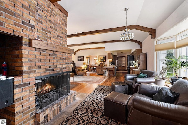 739 Stimson St, Cadillac, MI 49601 - living room with light wood-style floors, beamed ceiling, a brick fireplace, and a chandelier