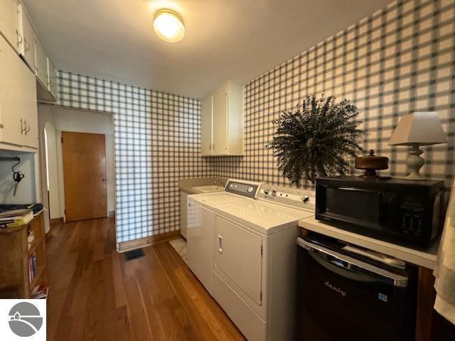 739 Stimson St, Cadillac, MI 49601 - laundry room featuring wallpapered walls, washer and dryer, wood finished floors, and baseboards